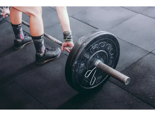 Egy sportoló nehéz súlyokat próbál felemelni